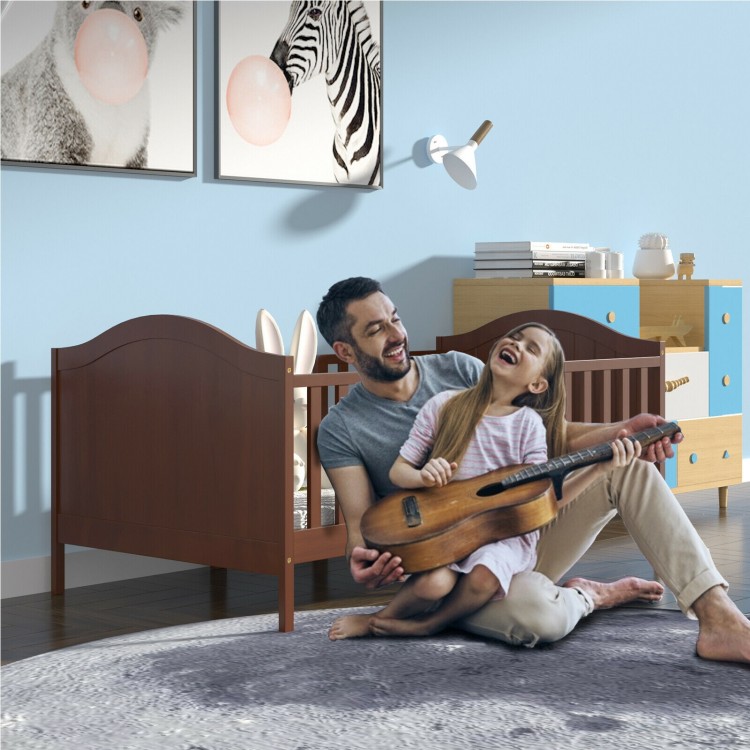 Classic brown convertible toddler bed with guardrails, designed for safety and independence, shown in a playful room.