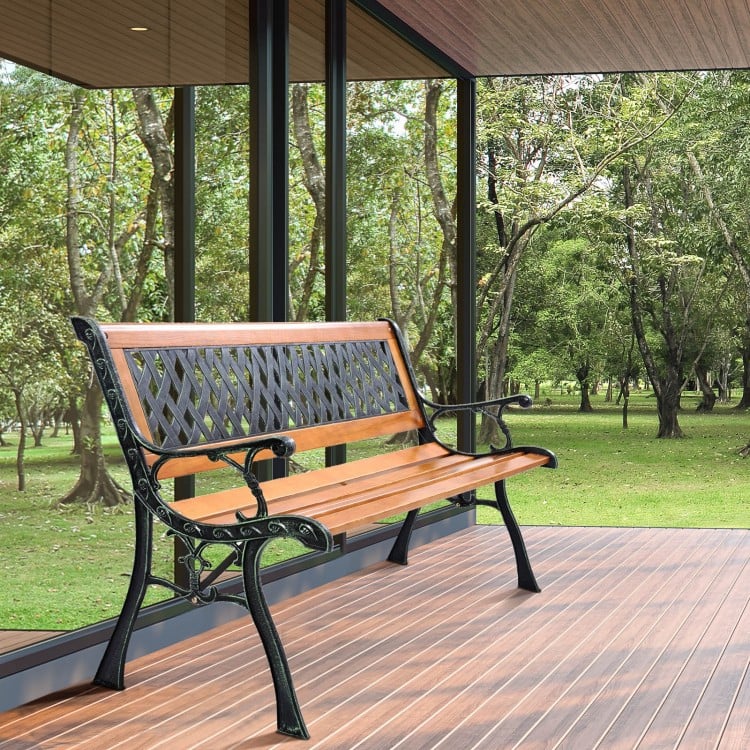 Outdoor cast iron patio bench with solid wood seat, designed for three adults, perfect for garden relaxation.
