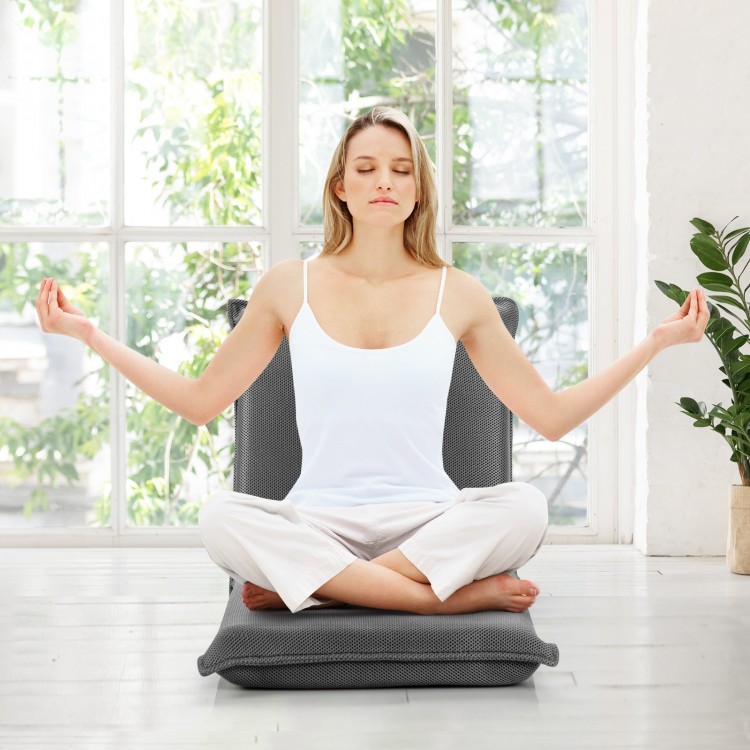 Adjustable gray floor chair in a meditative pose, featuring 6 positions for comfort in any setting.