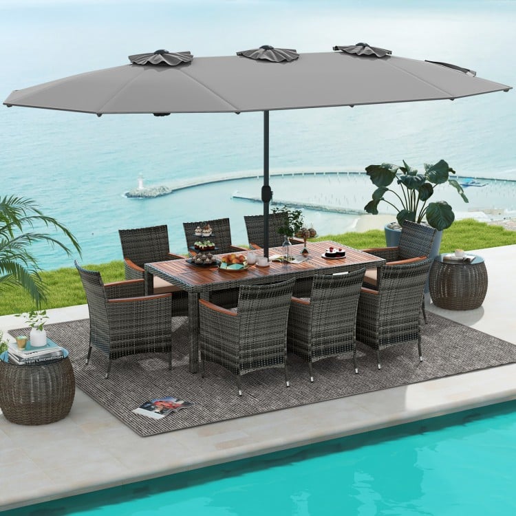 Elegant patio dining set arranged poolside, showcasing gray wicker chairs with soft cushions and large double-sided.