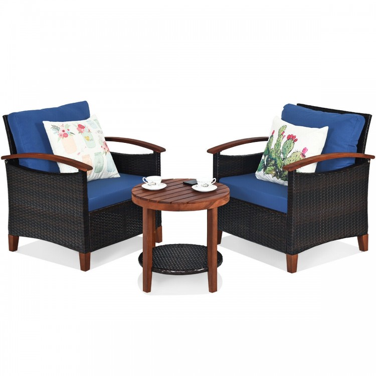 Patio rattan furniture set featuring two chairs with blue cushions and a wooden coffee table, perfect for outdoor.