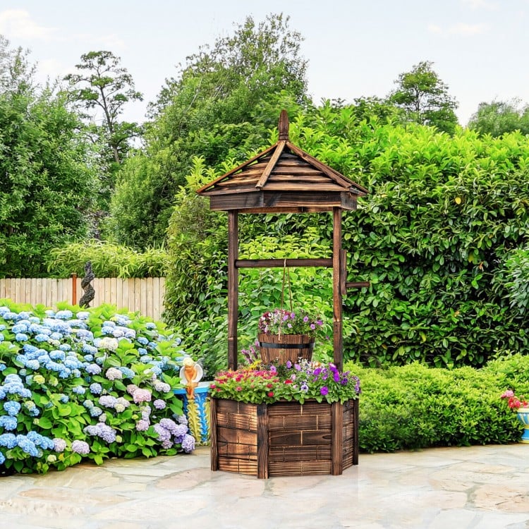 Rustic wooden wishing well planter with adjustable bucket, made from carbonized fir wood, ideal for garden or patio use.