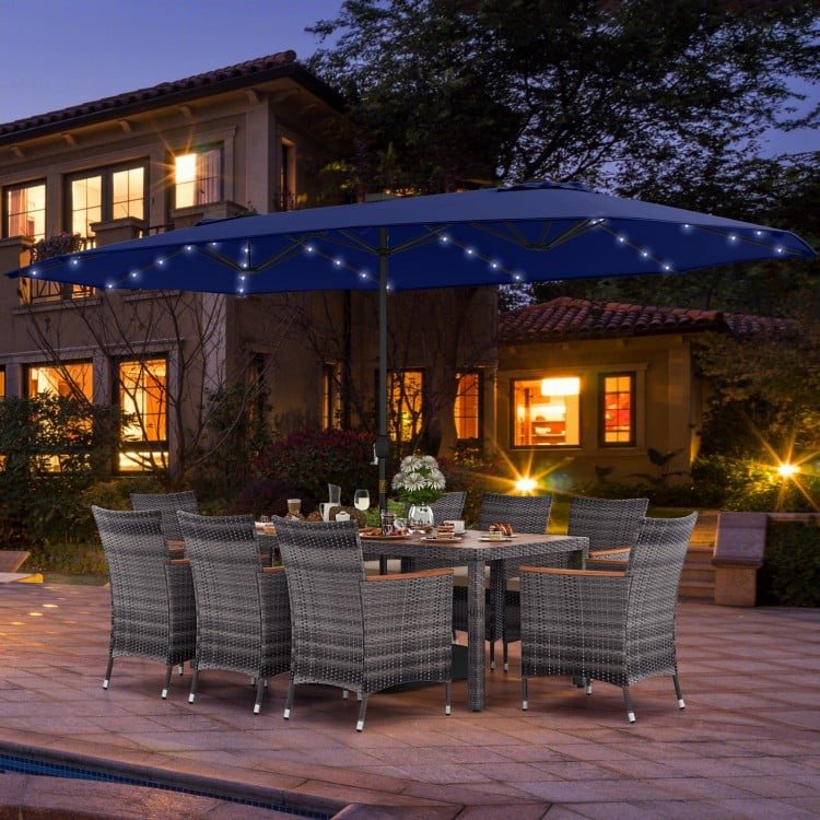 11-piece patio dining set featuring a navy double-sided umbrella and gray PE rattan chairs for outdoor gatherings.