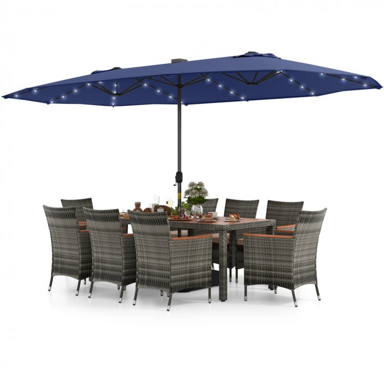 11-piece patio dining set featuring a navy double-sided umbrella, gray PE rattan chairs, and acacia wood table for.