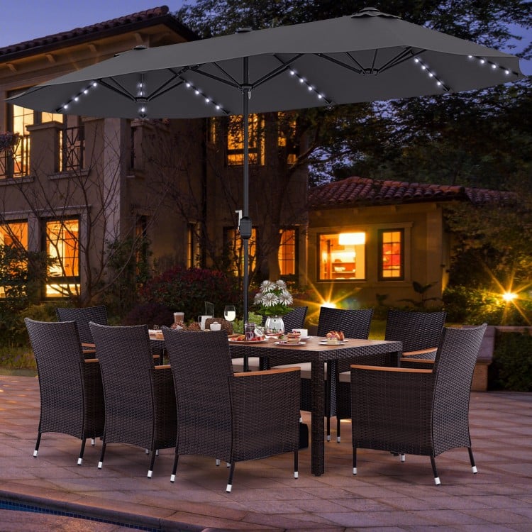 Patio dining set featuring a 15 ft double-sided umbrella, hand-woven PE rattan chairs, and an acacia wood table for.