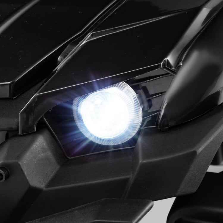 Bright LED headlight of a black 12V battery-powered electric vehicle for kids, enhancing safety and style.