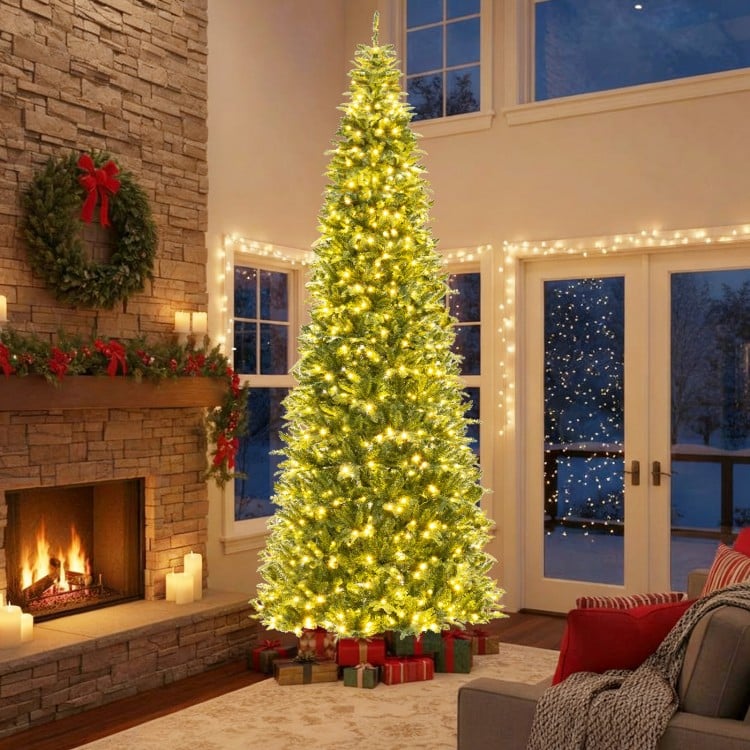 12 ft prelit artificial Christmas tree with 2517 branch tips, glowing LED lights, set in a cozy living room.