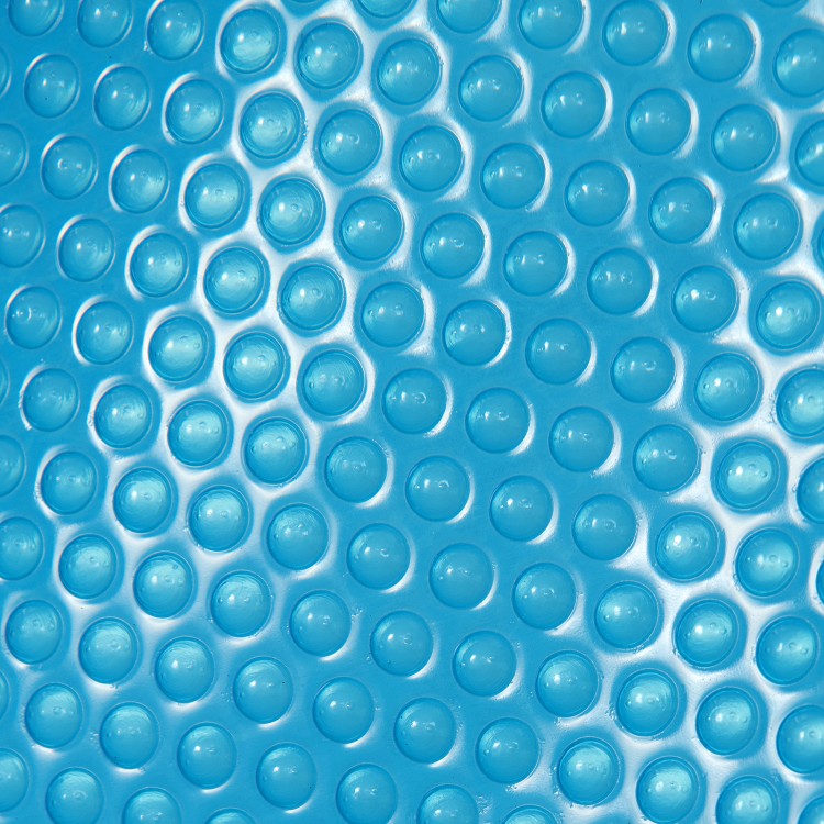 Close-up of a 12-mil thick PE swimming pool cover with bubble texture, designed for heat retention and water.