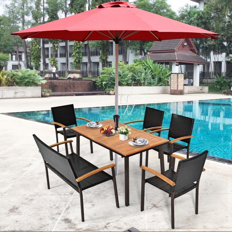 Acacia wood patio dining table with slatted surface and umbrella hole, perfect for outdoor gatherings by the pool.