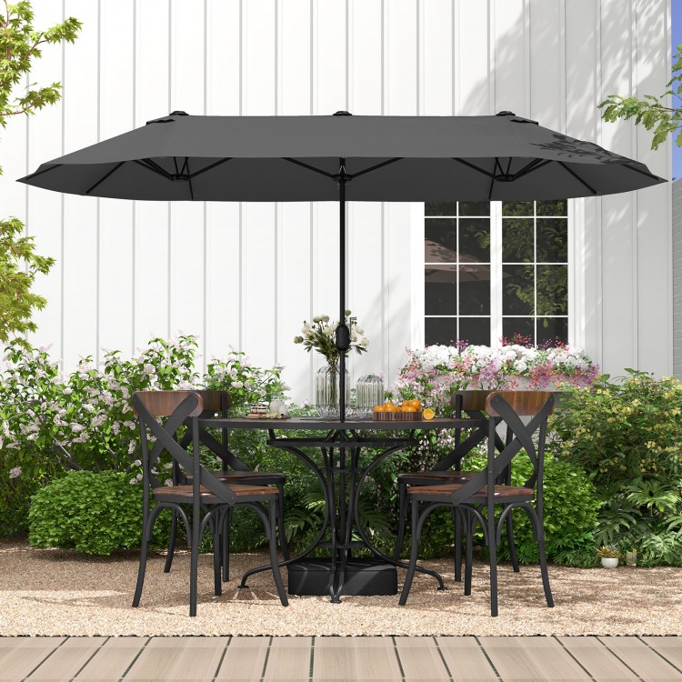 Double-sided gray patio umbrella with crank handle, providing ample shade for outdoor dining on the deck or patio.