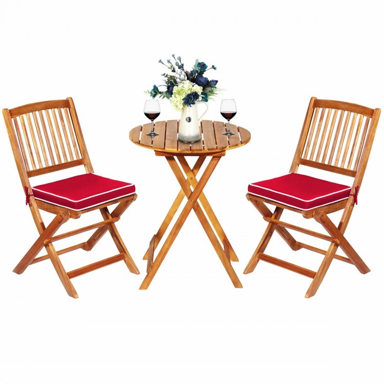 Folding wooden bistro set with red cushioned chairs and round table, perfect for outdoor dining and relaxation.