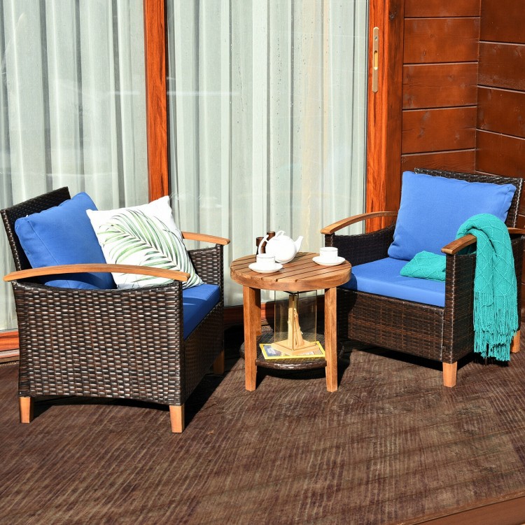 Patio rattan furniture set with blue cushions, featuring acacia wood frame and a coffee table for outdoor relaxation.