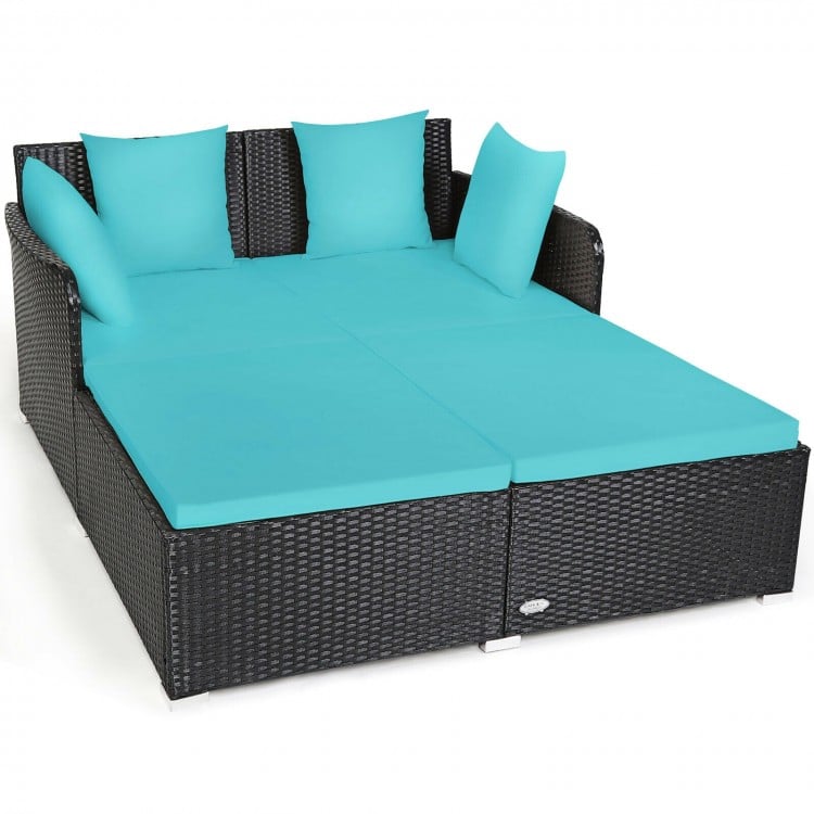Spacious outdoor rattan daybed in black with turquoise cushions and pillows, perfect for relaxation and comfort.