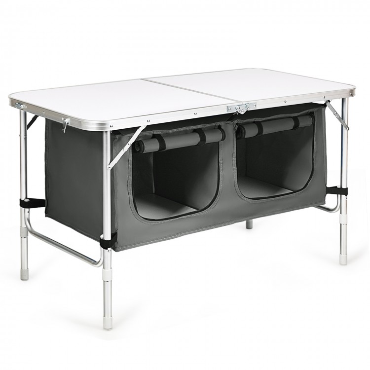 Height adjustable gray folding camping table with storage lockers, designed for easy transport and stability.