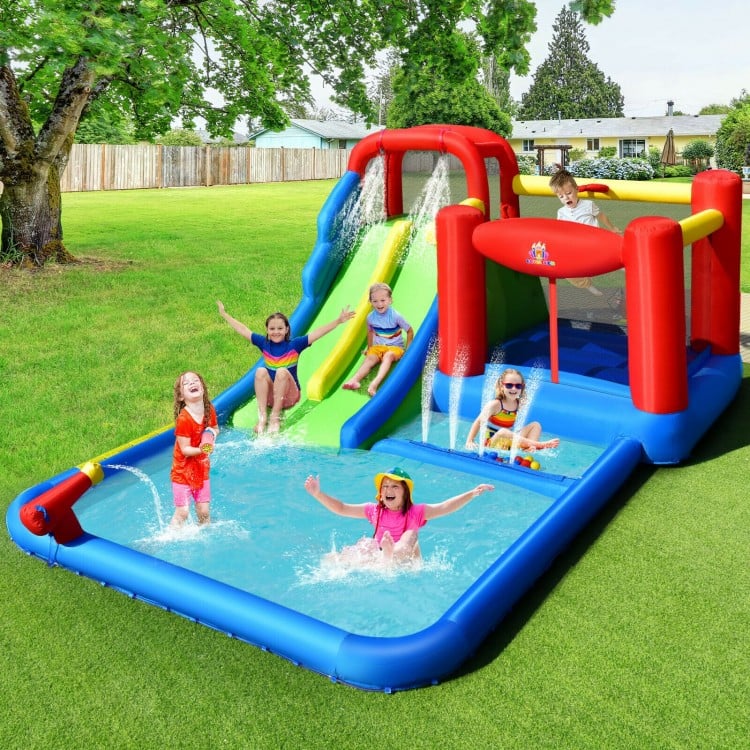 Inflatable water slide with climbing wall, basketball hoop, and splash pool for kids' summer fun in the backyard.