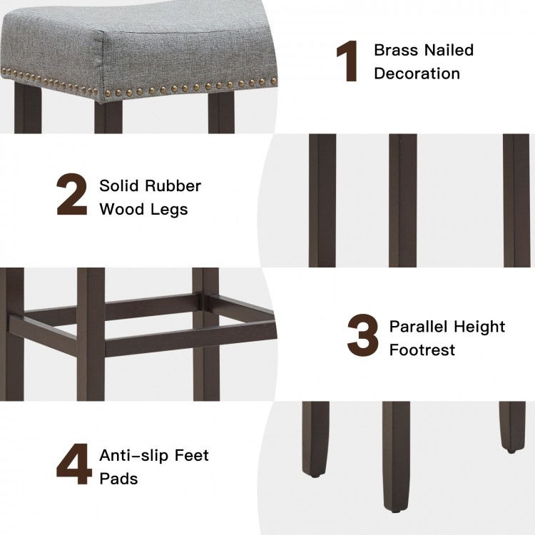 Gray saddle bar stool set with brass nailhead decoration, solid rubberwood legs, and ergonomic design for comfort.
