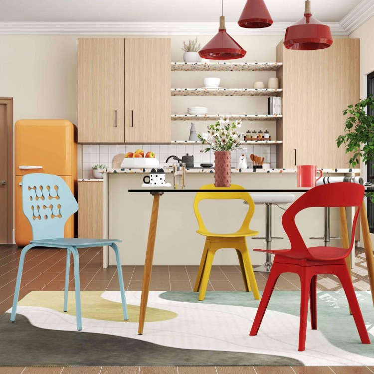 Colorful mid-century dining chairs in blue, yellow, and red around a glass dining table in a modern kitchen setting.