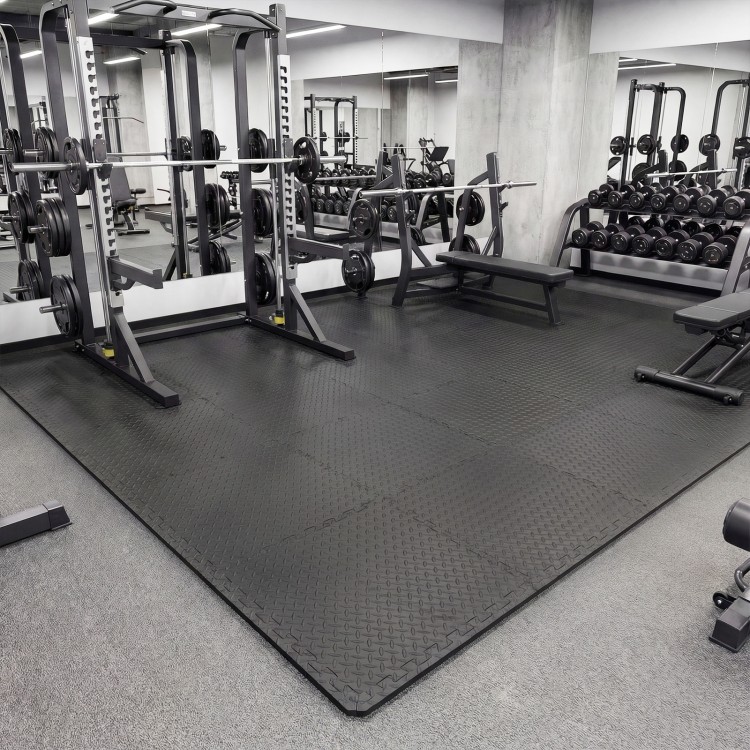 Black 1/2" puzzle exercise floor mats with non-slip texture, ideal for gyms and playrooms, providing impact cushioning.