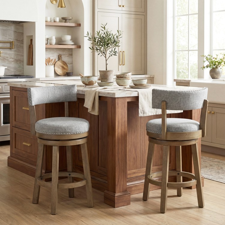 Swivel bar stool with upholstered back and footrest, featuring solid rubber wood legs and decorative nailhead detail.