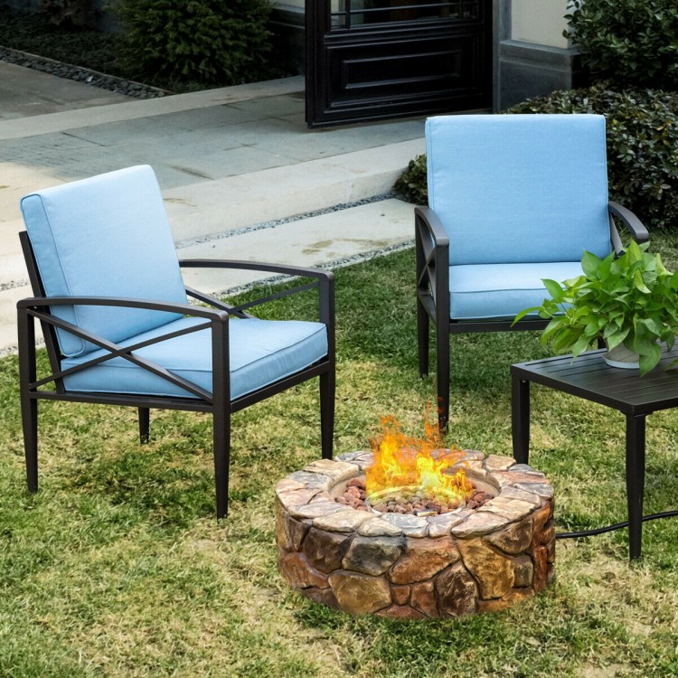 Blue cushioned chairs beside a 28-inch propane gas fire pit with natural stonework, perfect for outdoor gatherings.