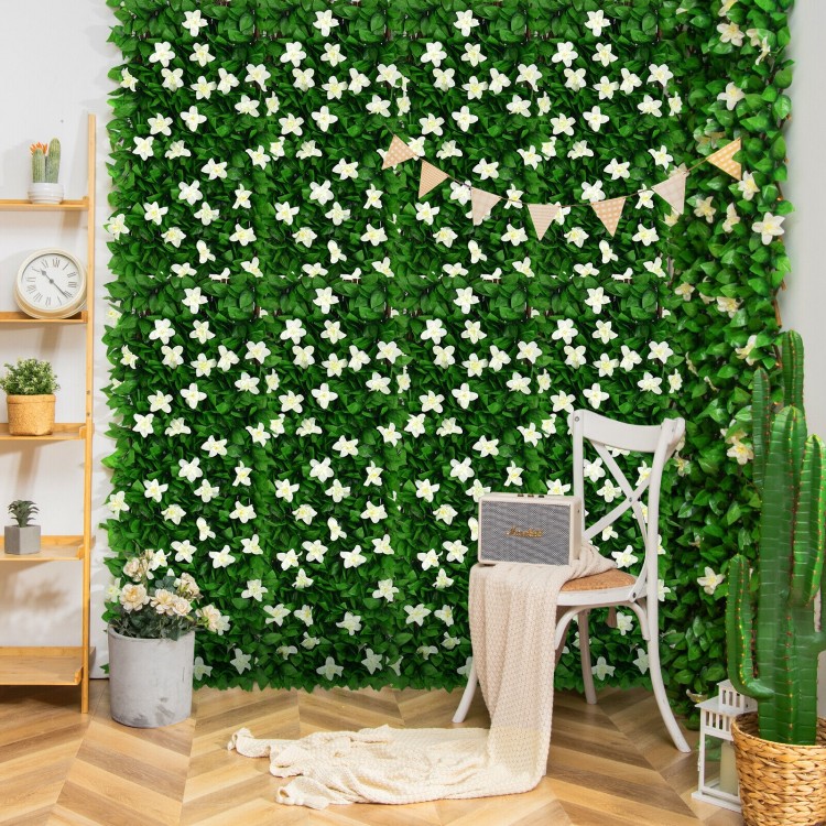 Expandable faux ivy privacy screen with white flowers, ideal for decorating balconies or as a backdrop for events.
