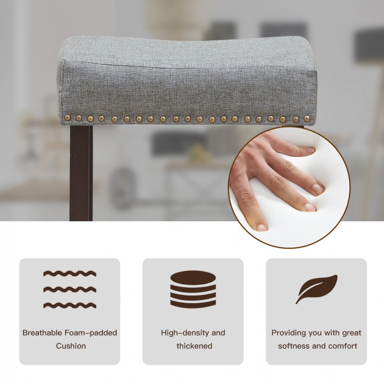 Close-up of the breathable foam-padded cushion of a gray bar stool, featuring classic nailhead studs for added elegance.