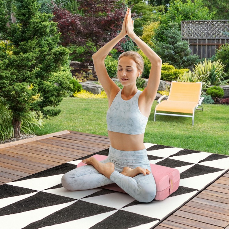 Yoga bolster pillow in pink with a washable cover, providing support for yoga exercises and relaxation outdoors.