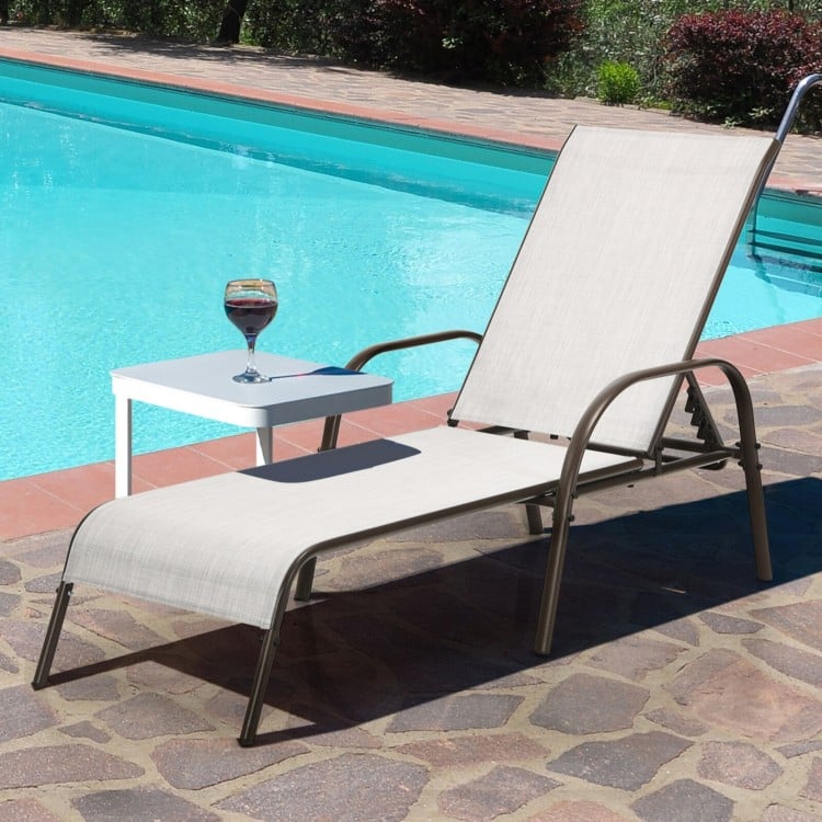 Gray outdoor patio lounge chair with adjustable reclining armrest, perfect for poolside relaxation.