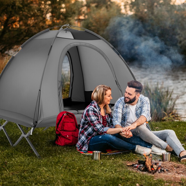 Two-person camping cot tent in grey, set up by a lake, ideal for outdoor adventures and stargazing at night.