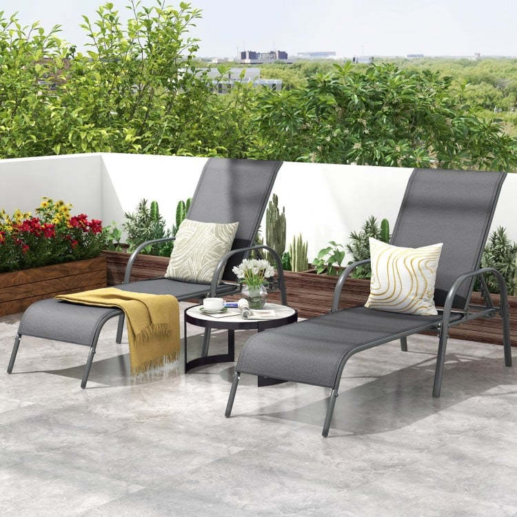 Two dark gray outdoor patio lounge chairs with adjustable armrests, perfect for relaxing on the balcony or poolside.