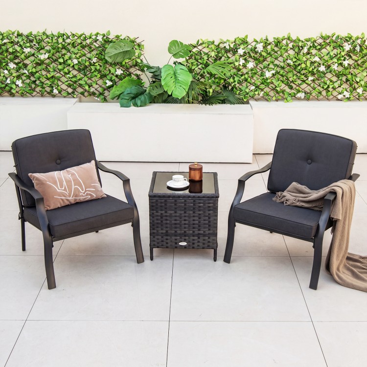 Two black metal patio chairs with cushions and a small table, perfect for backyard relaxation.