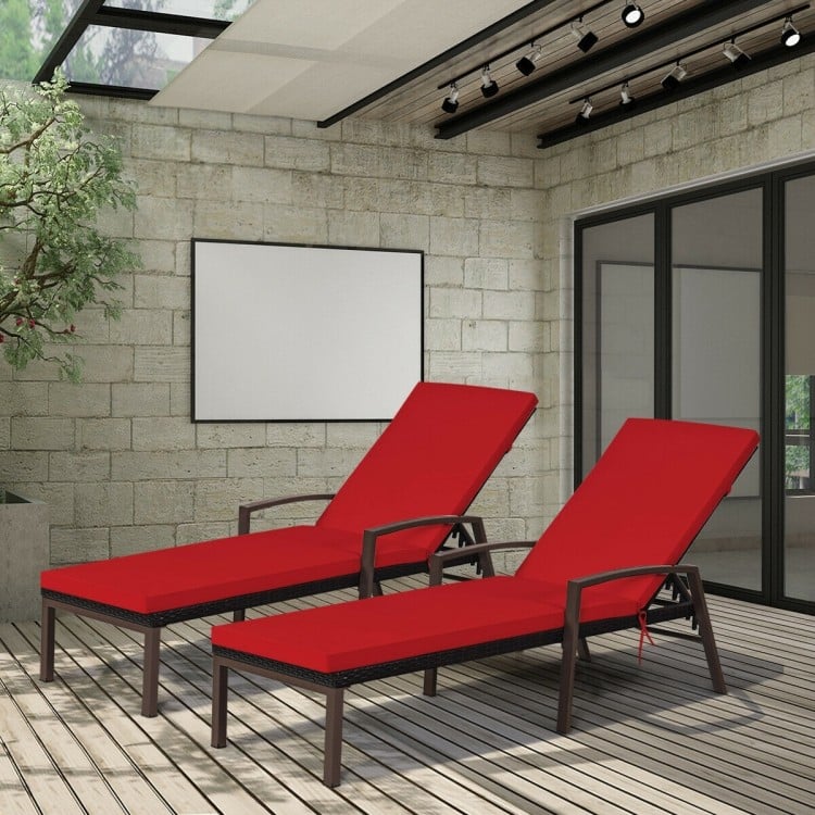 Two red adjustable back lounge chairs with removable cushions, made of durable rattan, perfect for outdoor relaxation.