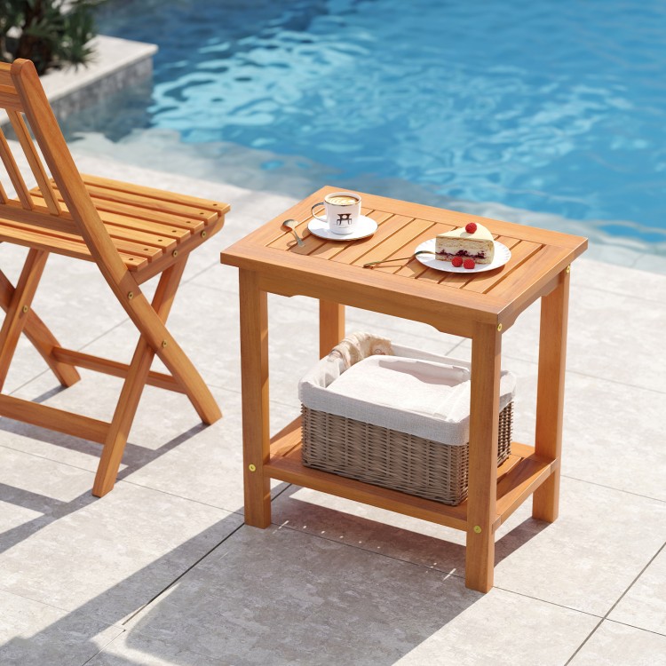 Acacia wood side table with slatted tabletop and storage shelf, perfect for patio or poolside use.