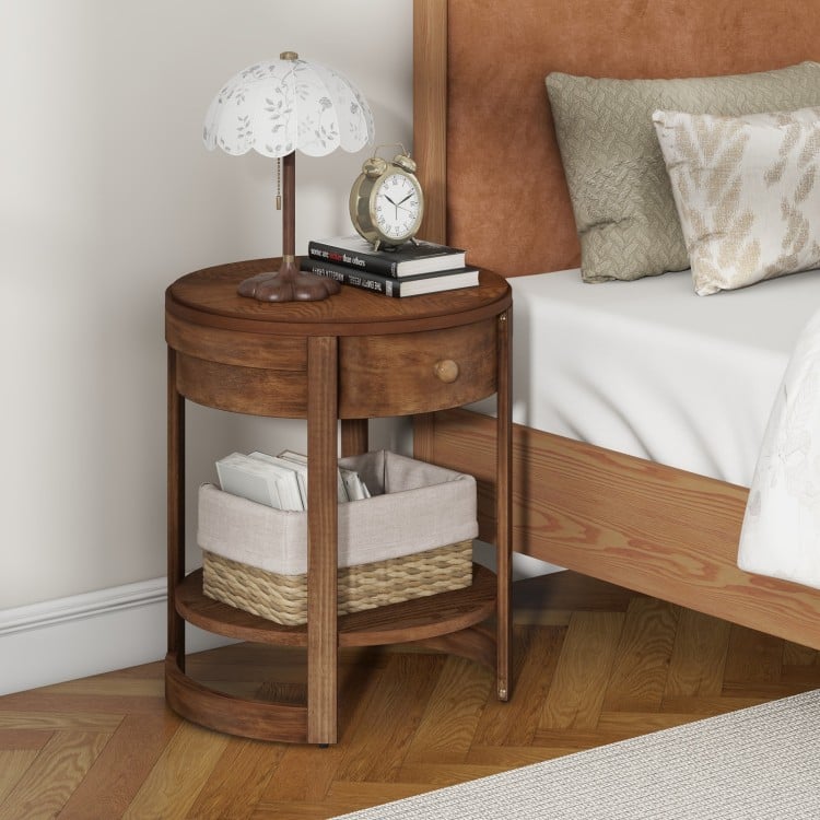 Round end table with drawer and shelf, featuring a sleek wood grain finish and sturdy rubber wood legs for bedroom use.