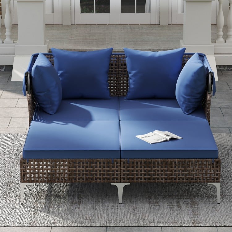 Outdoor daybed with navy cushions, made of PE wicker rattan, perfect for patio relaxation and sunbathing.