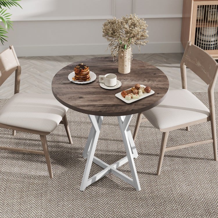 Round dining table with a natural wood-grain surface and sturdy X-shaped metal base, ideal for dining rooms or living.