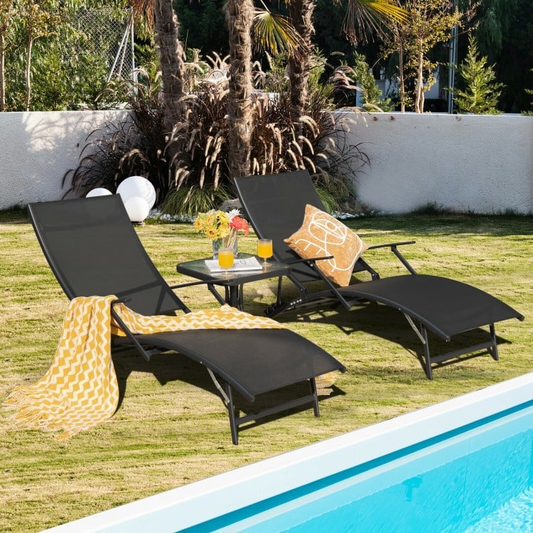 Black patio folding lounge chairs with armrests and adjustable backrests, perfect for poolside relaxation.