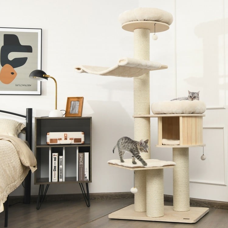 Wooden cat tree condo with sisal posts, featuring plush layers and a cozy hammock for playful cats in a stylish room.