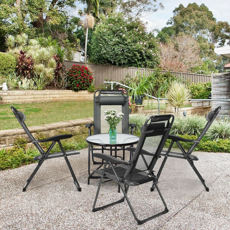 Four gray adjustable reclining folding chairs arranged around a table in a garden, perfect for outdoor relaxation.