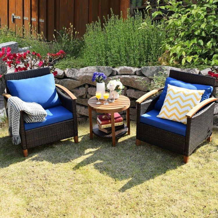 Two blue-cushioned patio chairs and a wooden coffee table in a garden setting, perfect for outdoor relaxation.