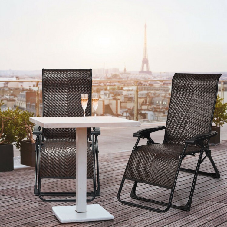 Two patio rattan zero gravity lounge chairs with a table, perfect for outdoor relaxation and summer gatherings.