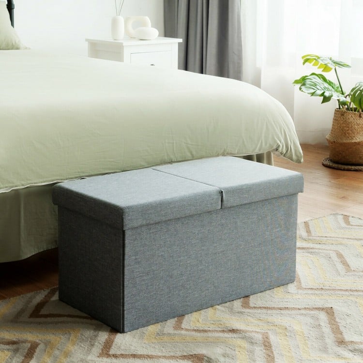 Light gray folding storage ottoman with lift top, sturdy MDF construction, and spacious interior for blankets and shoes.