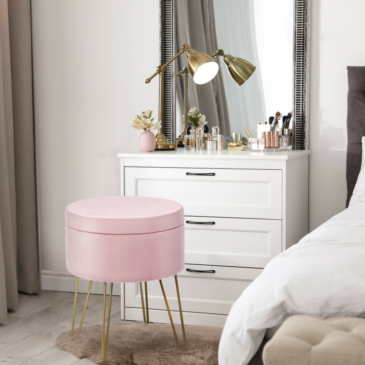 Round pink velvet storage ottoman with gold metal legs, perfect for a vanity or as a footrest in modern decor.