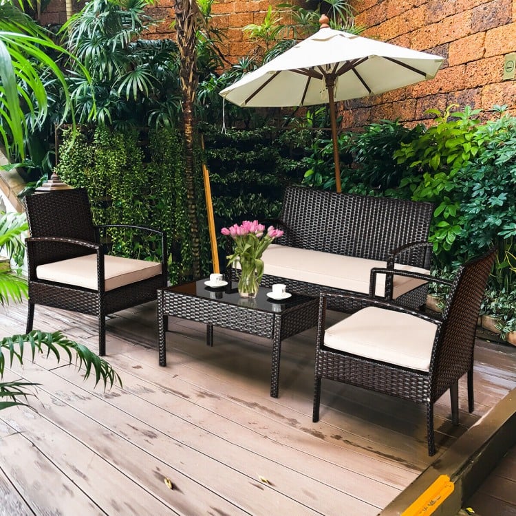4-piece patio rattan conversation set featuring a loveseat, two single sofas, and a coffee table for outdoor relaxation.
