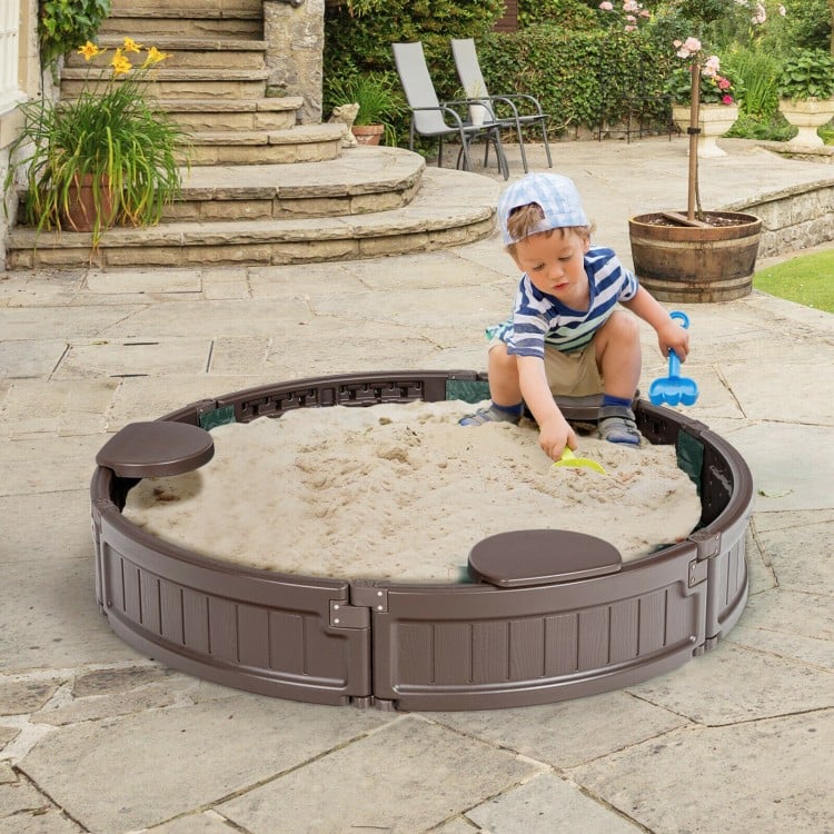 Child playing in a brown sandbox with built-in corner seats, featuring a dust-proof cover and smooth edges for safety.
