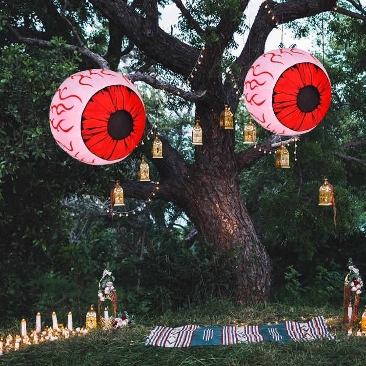 Two 3-foot Halloween inflatable eyeballs with red LED lights, creating a spooky atmosphere in a festive outdoor setting.