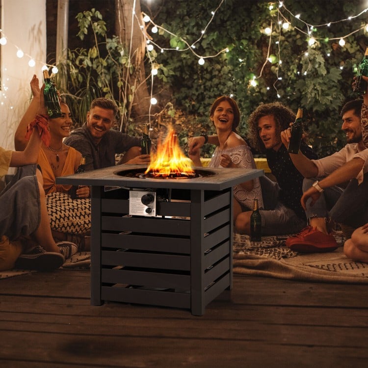 Square propane fire pit table with lava rocks, perfect for outdoor gatherings on patios or poolside.