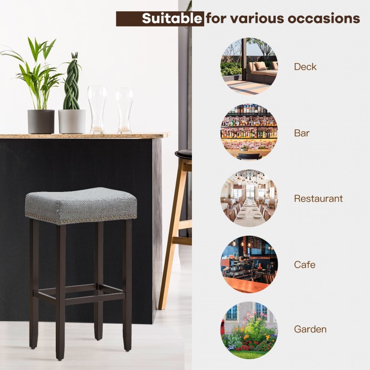 Gray nailhead saddle bar stool set with solid rubberwood legs, 29-inch height, perfect for bars and cafes.
