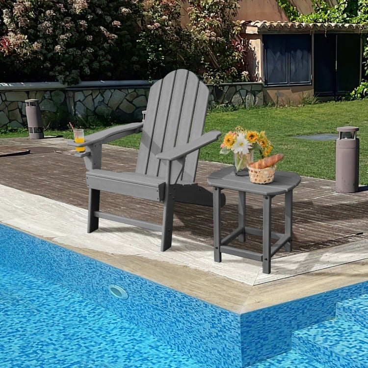 Gray outdoor Adirondack chair with built-in cup holder, placed poolside for comfortable backyard relaxation.