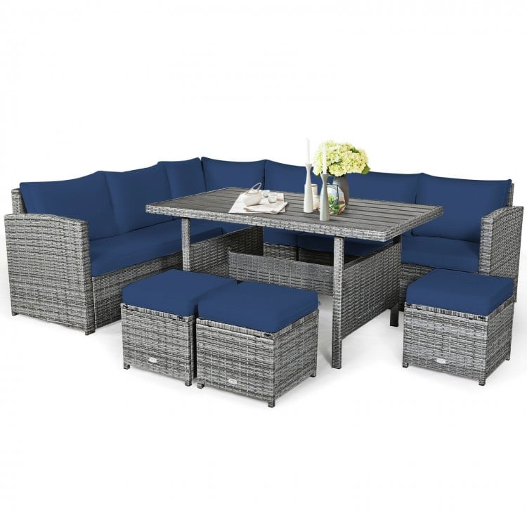 7-piece patio rattan dining furniture set with navy cushions, including sectional sofa, table, and ottomans for outdoor.